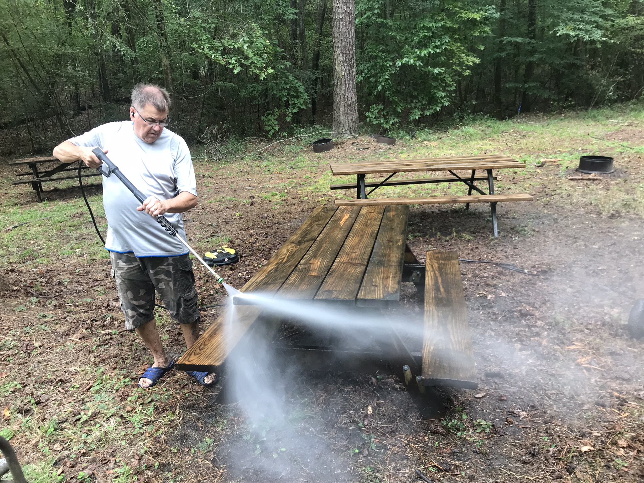 Keith Graybill pressure washes one of many picnic tables.